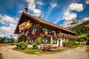 una casa de madera con flores delante en Bauernhof Lehengut en Pfarrwerfen