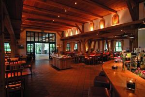 a restaurant with tables and chairs and a bar at Golfhotel Gut Apeldör in Hennstedt