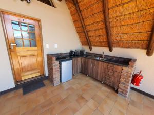 cocina con fregadero y puerta de madera en Masorini Bush Lodge, en Phalaborwa