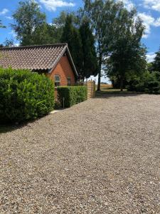 a house with a gravel driveway in front of a house at The Foxes Den in Assington