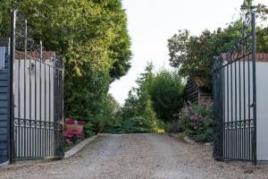an entrance to a garden with a gate and flowers at The Foxes Den in Assington
