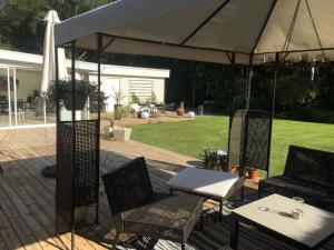 een patio met 2 stoelen en een parasol bij Rymlig villa med närhet till Tylösand och Halmstad GK in Halmstad