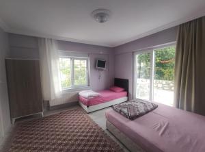 a bedroom with two beds and a window at Kaplan Apart - Pansiyon in Yeşilova