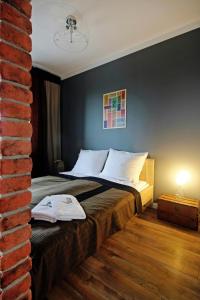 sypialnia z łóżkiem z ceglaną ścianą w obiekcie JTB Nautica Aparthotel w Szczecinie