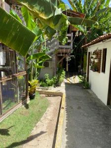 um caminho em frente a uma casa com grandes folhas verdes em Pousada Alquimia em Olinda