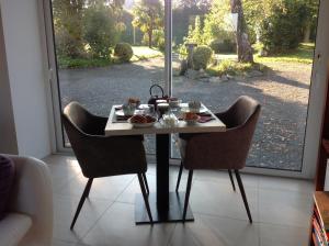 a table with a plate of food on it with two chairs at La Postellerie in Fleury