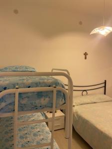 a bedroom with two bunk beds and a cross on the wall at Bilocale in pieno centro a Marettimo in Marettimo