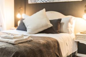 łóżko z poduszkami i ręcznikami na górze w obiekcie Seagull Apartment Hermanus w mieście Hermanus