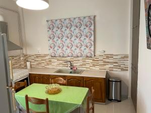 a kitchen with a table and a sink and a window at Saronic Hearts in Agioi Theodoroi