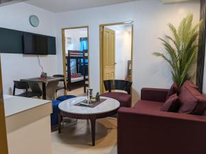 ein Wohnzimmer mit einem Sofa und einem Tisch in der Unterkunft 307 Anabelle Residence at Marina Spatial Condominium in Dumaguete