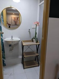 ein Bad mit einem Waschbecken und einem Spiegel in der Unterkunft 307 Anabelle Residence at Marina Spatial Condominium in Dumaguete