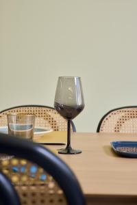 um copo de vinho sentado em cima de uma mesa em Olive suite, guesthouse by Villa Elia em Markopoulon