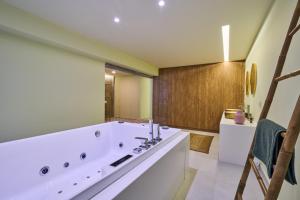 uma casa de banho com uma grande banheira branca num quarto em Olive suite, guesthouse by Villa Elia em Markopoulon