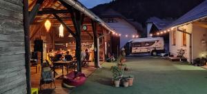 a group of people sitting at a table in a garage with a rv at BikeSki family hotel, b&b, apartaments, rooms in Mežica