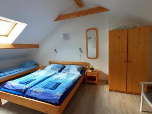 Schlafzimmer mit einem Bett mit blauer Bettwäsche und einem Spiegel in der Unterkunft Zátoň č.15 in Lenora