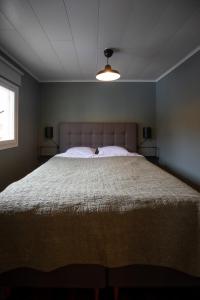 um quarto com uma cama grande e uma colcha branca em Sleep Inn em Jomala