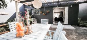 a white table with white chairs and vases on it at Seagull Hermanus in Hermanus