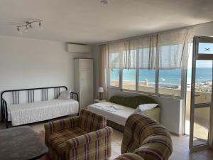 a room with a bedroom with a bed and a couch at Apartments Panorama Ravda in Ravda