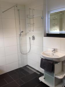 W łazience znajduje się prysznic i umywalka. w obiekcie Tankbar's Hotelchen w mieście Heroldsberg