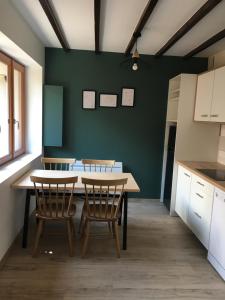 a kitchen with a table and chairs and a green wall at Maisonette 'La Toue' in Pyrenees National Park in Arrens-Marsous