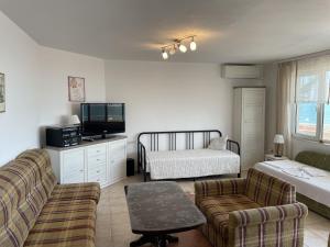 a living room with a couch and a bed at Apartments Panorama Ravda in Ravda
