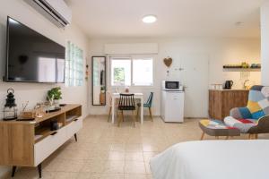 um quarto com uma cama e uma cozinha com uma mesa em ירוק באלה - דירת נופש ברמת ישי em Ramat Yishay
