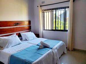 two beds in a room with a window at Sweet Retreat-1 in Lusaka