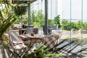 een houten tafel en stoelen in een kamer met ramen bij Arken Hotel & Art Garden Spa in Göteborg