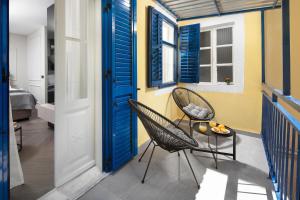 2 stoelen en een tafel op een balkon met blauwe luiken bij Oia Room in Labin