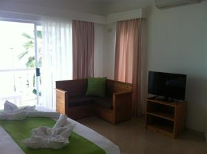 um quarto de hotel com uma cama e uma televisão em Marie-France Beach Front Apartments em La Digue