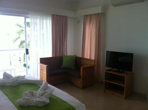 Habitación de hotel con cama y TV en Marie-France Beach Front Apartments, en La Digue