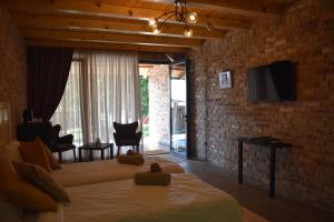 a bedroom with a bed and a tv on a brick wall at Helvecija 1880 in Vršac