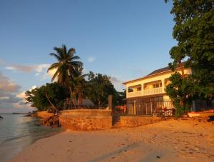 a building on the beach next to the ocean at Marie-France Beach Front Apartments in La Digue