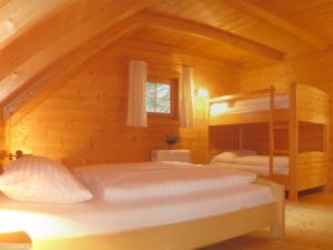 Uma cama ou camas num quarto em Almhüttendorf Klippitztörl