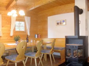 uma sala de jantar com um fogão a lenha numa cabina em Almhüttendorf Klippitztörl em Klippitztorl