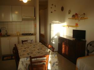 a small kitchen with a table and a refrigerator at Aurora e Andrea San Vito lo Capo in San Vito lo Capo