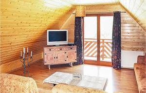 ein Wohnzimmer mit einem TV an einer Holzwand in der Unterkunft Zakatek Mala in Kołczewo