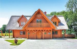 una gran casa de madera con techo de gambrel en Zakatek Mala en Kołczewo