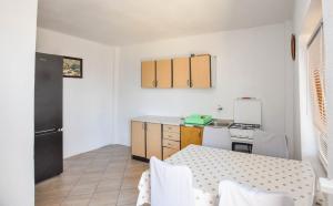 a small kitchen with a table and a refrigerator at House Mateo in Neviđane