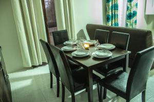 una mesa de comedor y sillas con platos y vasos. en Apartment Triq is-Silla, en Marsaskala