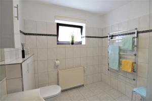 a bathroom with a toilet and a window at Ferienwohnung Kube in Grömitz