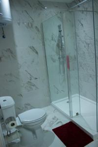 a white bathroom with a shower and a toilet at Apartment Triq is-Silla in Marsaskala