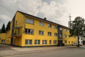 a yellow building on the side of a street at Apado-Hotel garni in Homburg