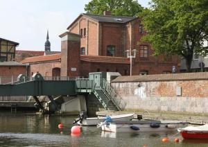 施特拉尔松德Altes Zollhaus Stralsund的河上一座桥,河上有船 更多12张照片