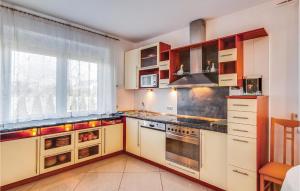 una cucina con mobili bianchi e una grande finestra di Lovely Home In Grzybowo With Wifi a Grzybowo
