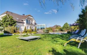 a yard with two chairs and a hammock in front of a house at Lovely Home In Grzybowo With Wifi in Grzybowo