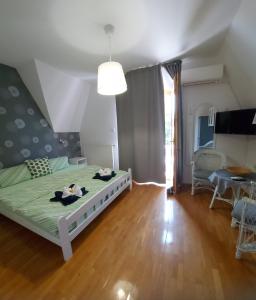a bedroom with a bed and a living room at Gabi Apartmanház in Balatonlelle