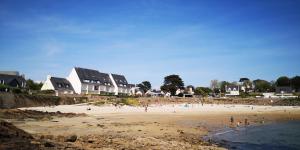 a group of people on a beach with houses at Appt entier Résidence de la Plage Vue Mer Port Navalo in Arzon