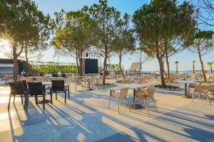 a patio with tables and chairs and trees at Crystal Centro Resort - Ultimate All Inclusive in Lara