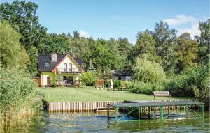 ノベ・バルプノにあるStunning Home In Nowe Warpno With 5 Bedrooms And Saunaの湖畔に腰掛けた家